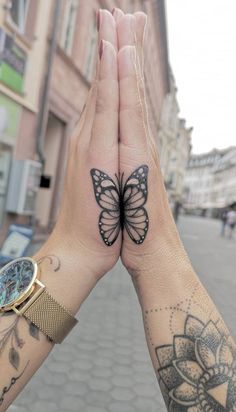 two people holding their hands up to show the butterfly tattoo on their wrist and wrist