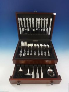 an assortment of silverware in a wooden box