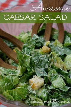 a salad with lettuce and croutons in a glass bowl on a checkered tablecloth