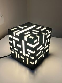 a black and white light that is on top of a table in the shape of a cube