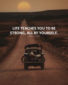 a motorcycle parked on the side of a dirt road next to a truck with a quote about life teaches you to be strong, all by yourself