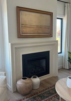 a living room filled with furniture and a fire place in front of a painting on the wall