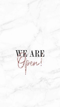 the words we are open written in red ink on a white marble background with black lettering