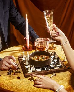 people sitting at a table with wine glasses in front of them and playing checkers