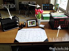 an office desk with various items on it and labeled in the words,'n & out box '