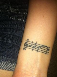 a small wrist tattoo with musical notes on it