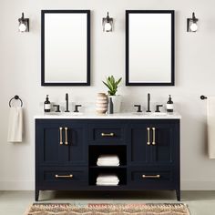 two mirrors are above the double sink vanity in this white and black bathroom with gold trim