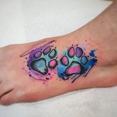 a colorful foot tattoo with paw prints on it