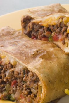 two burritos sitting on top of a yellow plate