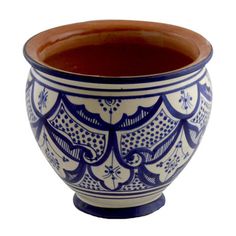 a blue and white bowl with designs on the rim is sitting in front of a white background