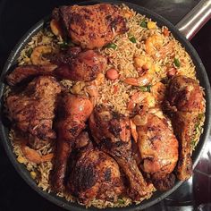 a pan filled with chicken and rice on top of a stove