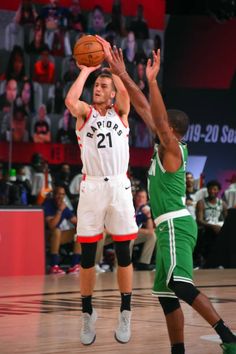 two men playing basketball in front of an audience