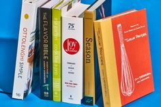 a stack of books sitting on top of a blue table next to an orange book bag