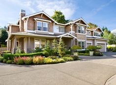 a large house with lots of trees and bushes around it's front lawn area