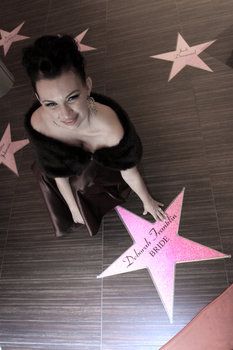 a woman sitting on top of a pink star