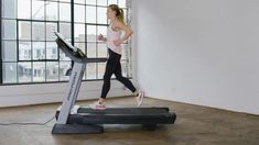 a woman is running on a treadmill