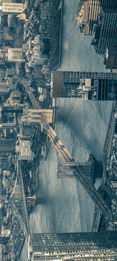 an aerial view of a city with lots of tall buildings and water in the foreground