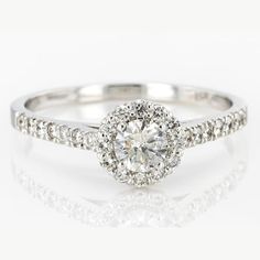 a white gold engagement ring with diamonds on the band and an oval center stone in the middle