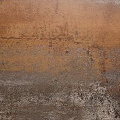 an old, dirty wall with some brown paint on the top and bottom part of it