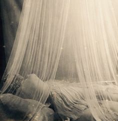 an old photo of a bed with mosquito netting