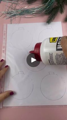 someone is using glue to decorate the top of an ornament on a sheet of paper