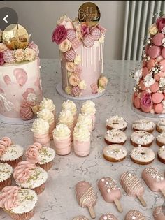 a table topped with cakes and cupcakes covered in frosting