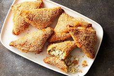 several pastries on a white plate with sprinkled crusts and powdered sugar