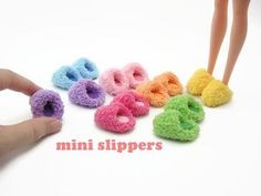 there is a hand that is holding some miniature slippers in the shape of letters