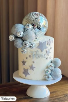 a white cake with silver stars and disco balls on top