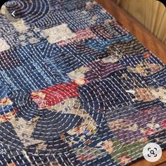 a close up of a blue and red rug on a wooden table