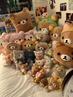 there are many teddy bears on the bed together and one is wearing a bear hat