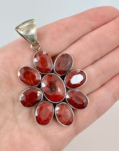 Wow! This is a stunning vintage sterling silver large pendant. This is a designer piece from Arya, whose designs always have amazing stones. It is set with big red corundum Indian ruby gemstones. I have a personal love of corundum rubies. The color saturation on this opaque stone is stunning. These stones are faceted which makes them sparkle light mad These have been tested to be genuine. There are 9 stones with each one is bezel set. This is created with nice heavy sterling silver. The stones a Ruby Pendant, Ruby Jewelry, Vintage Pendant, Ruby Gemstone, Bezel Setting, Sterling Silber, Vintage Sterling Silver, Vintage Silver, Jewelry Necklace Pendant