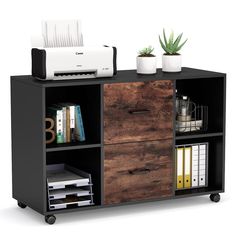 a black and brown bookcase with two drawers on wheels next to a printer machine