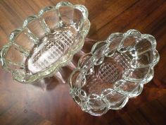 two glass dishes sitting on top of a wooden table