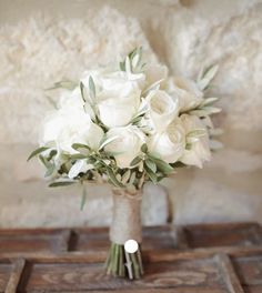 a bouquet of white flowers sitting on top of a table