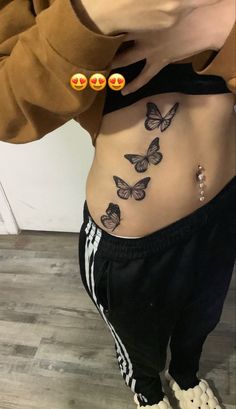 a woman's stomach with butterflies on it and two smiley faces drawn on the side