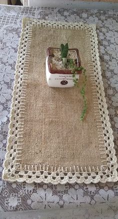 a small plant is growing out of a tiny potted plant on a placemat