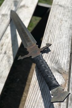 a large knife sitting on top of a wooden bench