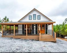 a small white house sitting on top of a gravel field