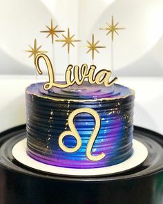 a purple and blue cake with gold stars on top