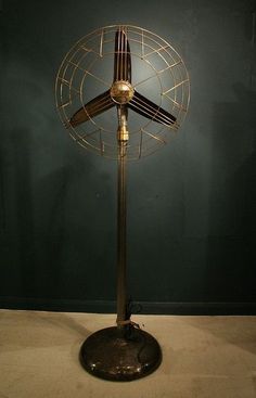 a metal fan sitting on top of a table next to a green wall and floor