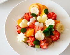 a white plate topped with fruit salad on top of a table