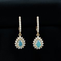 Product Details Bridal teardrop earrings crafted in gold, featuring pear-cut Ethiopian opal and round moissanite gems. These earrings are a stunning choice for your special day, adding charm to any bridal look. The elegant combination of the pear-cut opal and round moissanite gems creates a beautiful contrast and shine brightly against the gold setting. Ideal for the bride who wants a touch of timeless sophistication on her wedding day, these earrings are the perfect finishing touch. They are de Teardrop Bridal Earrings, Bridal Look, Round Moissanite, Earring Crafts, Pear Cut, Bridal Looks, Bridal Earrings, Teardrop Earrings, Ethiopian Opal