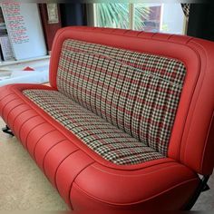 a red couch sitting in front of a window