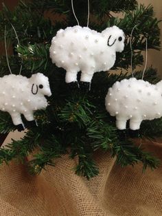 three sheep ornaments hanging from a christmas tree