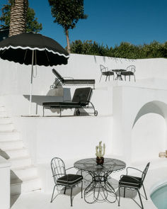 an outdoor table and chairs next to a pool