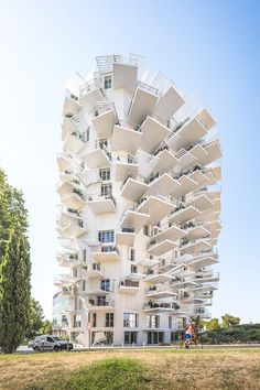 a tall white building with balconies on it's sides and lots of windows