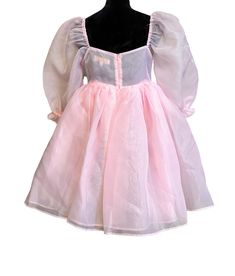 Pink Organza Babydoll Dress This is the babydoll dress for a kind-hearted and adventurous princess. It's made entirely of high quality sheer organza fabric, which makes it the puffiest, most dramatic babydoll dress in all of our collections! The skirt is made of three layers and the body is double layered. All of the seams are inside of the layers to prevent fraying and itchiness. The elastic at the the bottom of the sleeve creates a ruffle effect. It closes at the back with an invisible zipper. Pink Feminine Dress For Costume Party, Feminine Pink Dress For Costume Party, Pink Barbiecore Dress With Ruffles, Princess Dress With Fitted Bodice In Organza, Balletcore Puff Sleeve Party Dress, Pink Fitted Fairy Dress For Fancy Dress, Pink Puff Sleeve Tulle Dress, Pink Princess Dress With Puff Sleeves, Princess Style Party Dress With Sheer Bodice