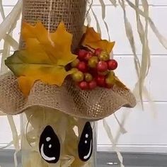 a scarecrow hat with leaves and berries on it