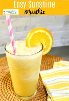 an orange smoothie in a glass with a striped straw